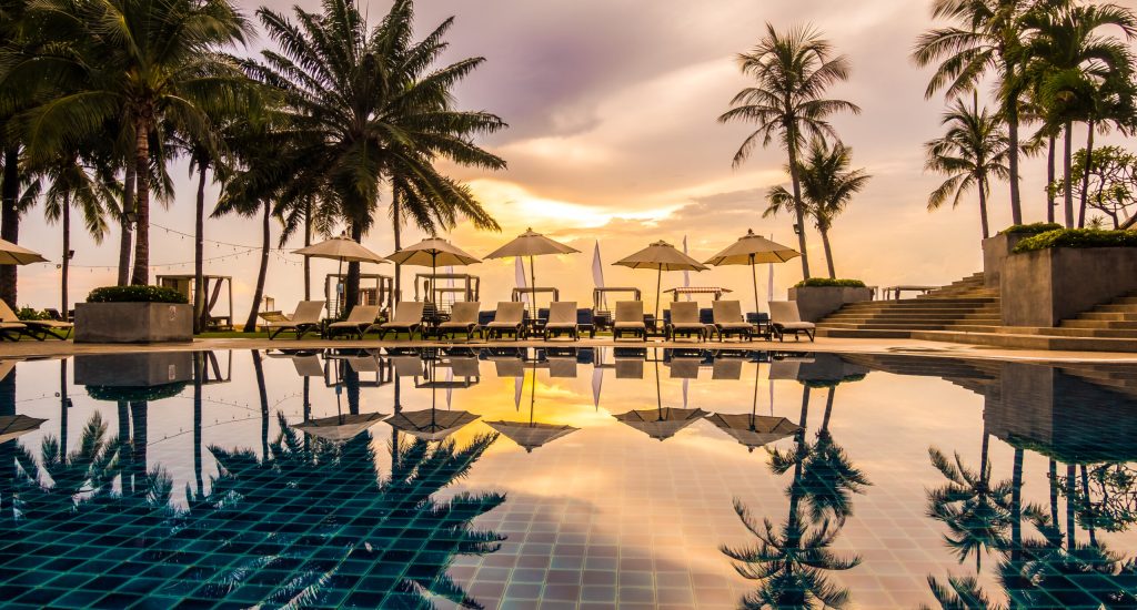 Beautiful luxury outdoor swimming pool with umbrella and chair in hotel and resort for travel and vacation